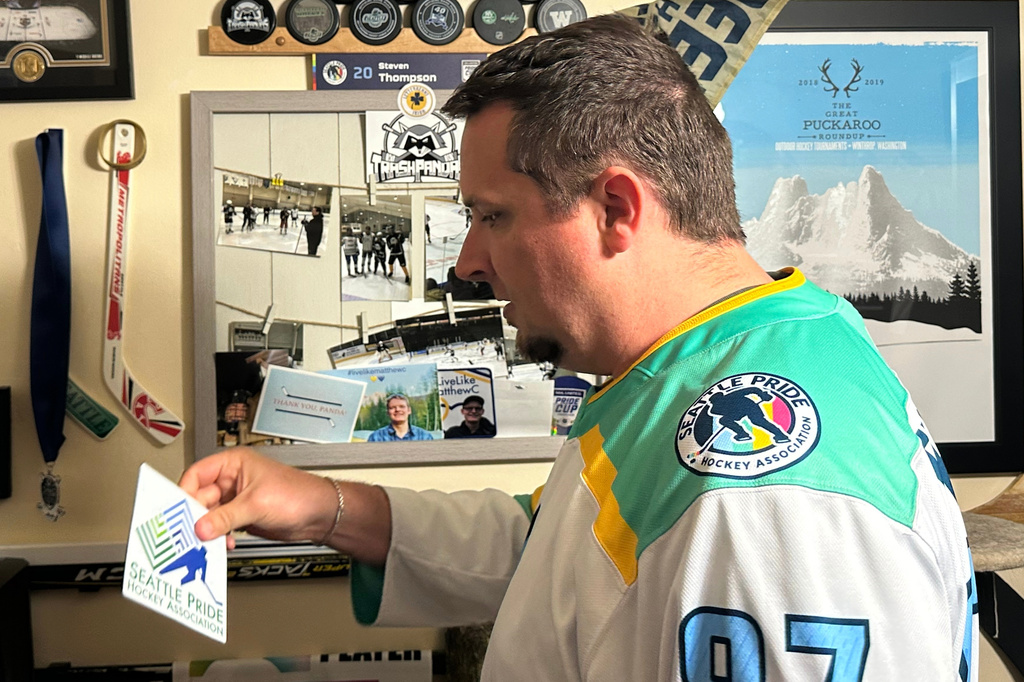 Steven Thompson, co-founder of the Seattle Pride Hockey Association (SPHA), sifts through some of his hockey memorabilia at his home in Des Moines, Wash., Monday, April 27, 2026. (AP Photo/Andrew Destin)
