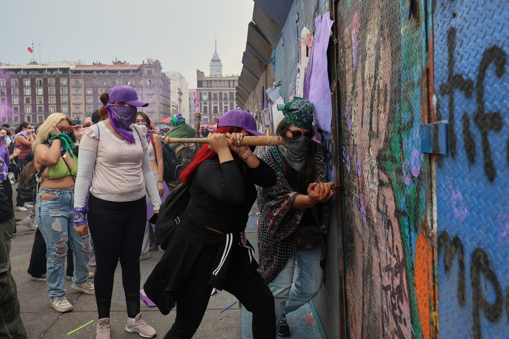 Protesters try to break through a barrier during a rally marking International Women's Day, at the Zocalo in Mexico City, Sunday, March 8, 2026. (AP Photo/Ginnette Riquelme)