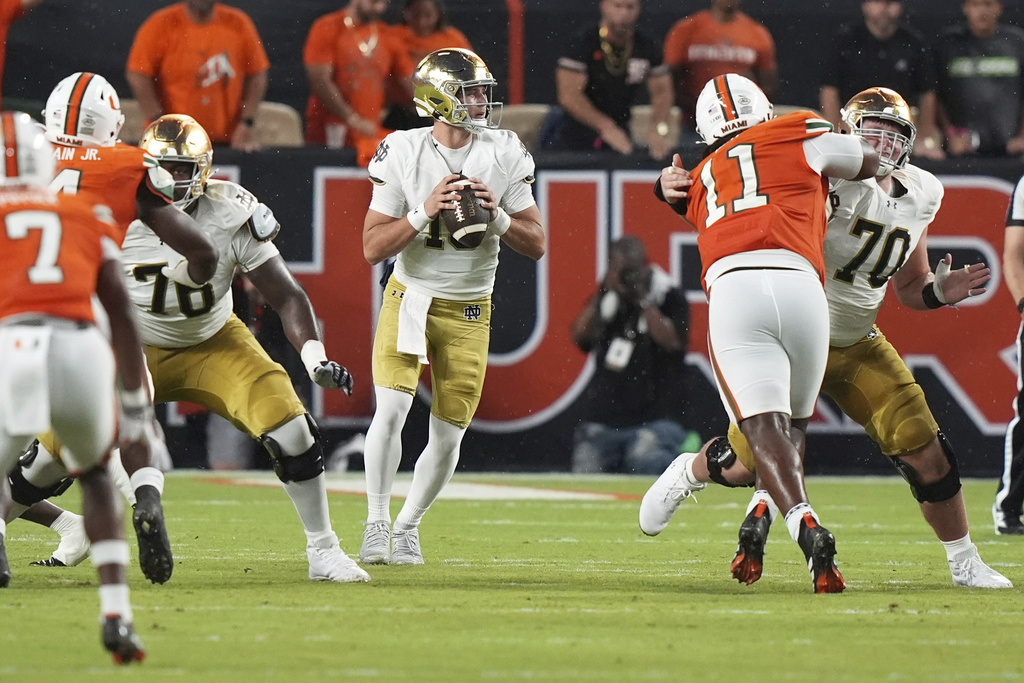 Notre Dame quarterback CJ Carr, center, looks to pass during the first half of an NCAA college football game against Miami, Sunday, Aug. 31, 2025, in Miami Gardens, Fla. (AP Photo/Lynne Sladky)