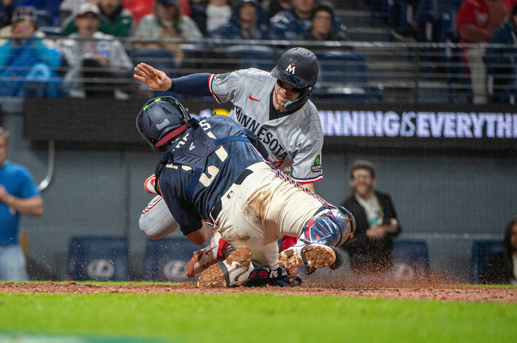 Minnesota Twins' Ryan Jeffers, top, is tagged out by Cleveland Guardians' Austin Hedges, front, at home plate during the sixth inning of a baseball game, Friday, May 8, 2026, in Cleveland. (AP Photo/Phil Long)