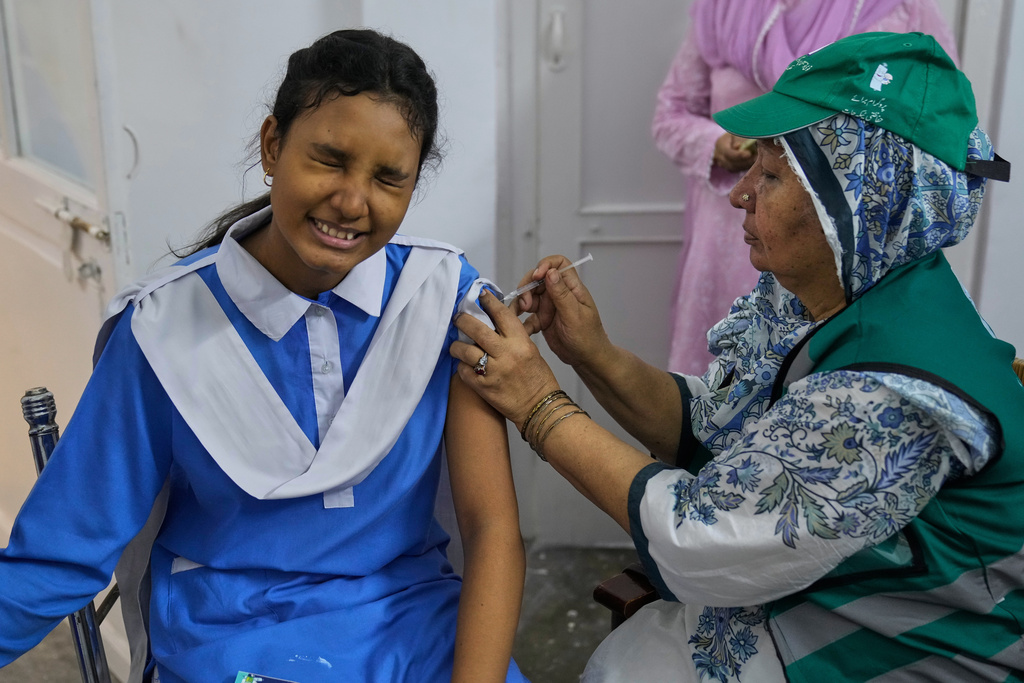 A health worker gives an injection of human papillomavirus (HPV) vaccine to a girl during a campaign aiming to protect girls from cervical cancer, at a school in Lahore, Pakistan, Monday, Sept. 22, 2025. (AP Photo/K.M. Chaudary)