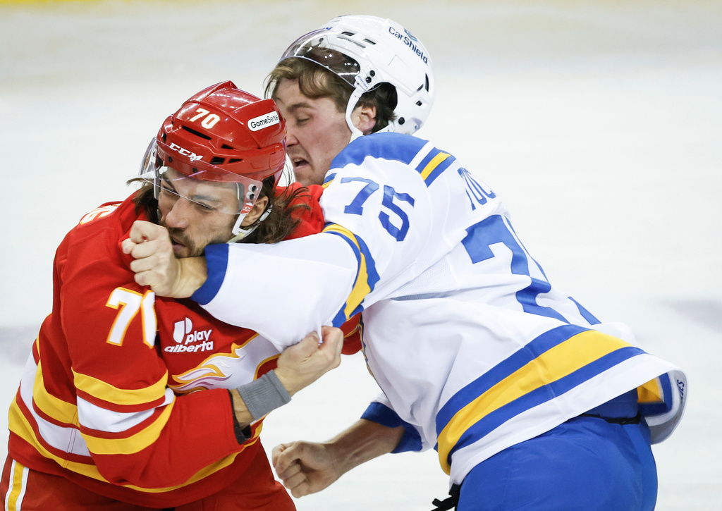 St. Louis Blues' Tyler Tucker, right, fights with Calgary Flames' Ryan Lomberg during the second period of an NHL hockey game in Calgary, Alberta, Saturday, Oct. 11, 2025. (Jeff McIntosh/The Canadian Press via AP)
