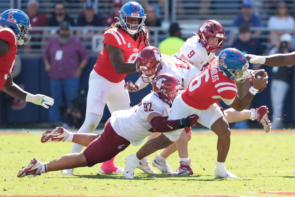 Mississippi quarterback Trinidad Chambliss (6) is tackled by Washington State defensive lineman Darrion Dalton (92) during the second half of an NCAA college football game, Saturday, Oct. 11, 2025, in Oxford, Miss. (AP Photo/Rogelio V. Solis)
