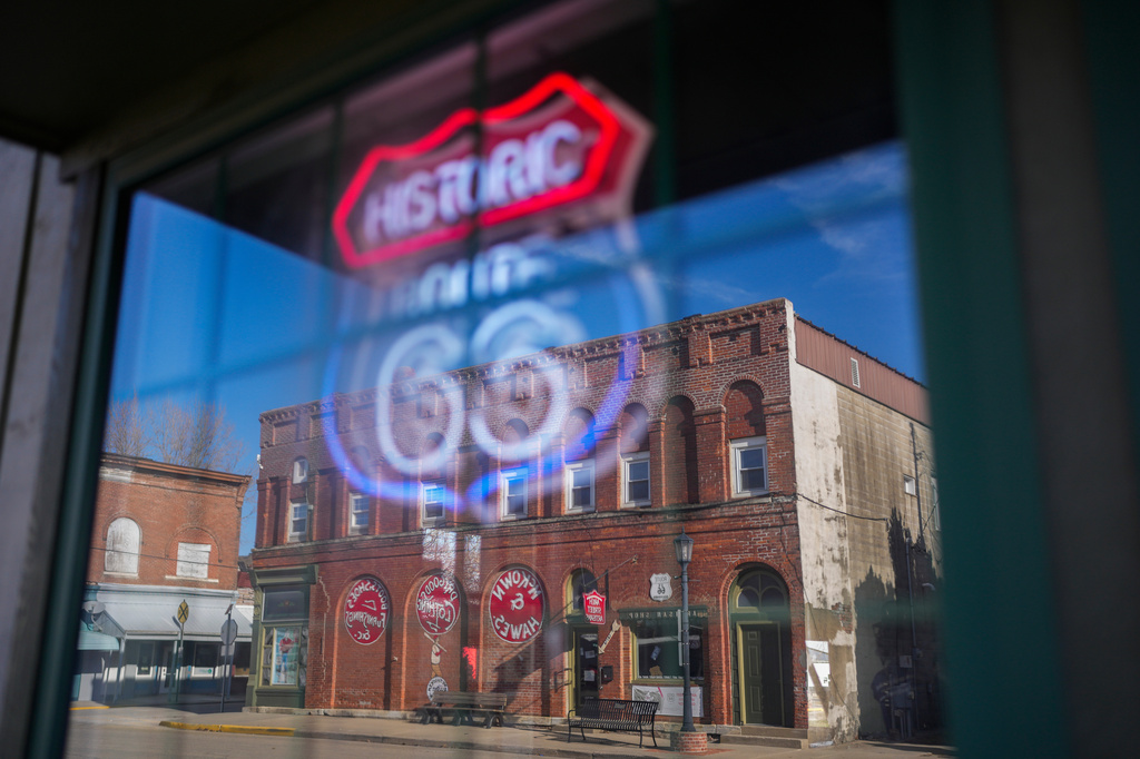The McKown & Hawes Building is reflected in a window with a neon Route 66 sign in Atlanta, Ill., Wednesday, Jan. 7, 2026. (AP Photo/Erin Hooley)