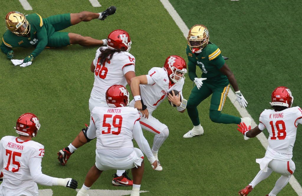 Houston quarterback Conner Weigman, center, scores on a run play against the Baylor defense in the first half of an college football game, Saturday, Nov. 29, 2025, in Waco, Texas. (Rod Aydelotte/Waco Tribune-Herald via AP)