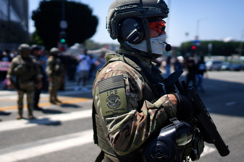 FILE - An ICE Special Response Team member stands guard outside the Metropolitan Detention Center, while protesters gather outside to denounce the ICE, U.S. Immigration and Customs Enforcement, operations, June 10, 2025, in downtown Los Angeles. (AP Photo/Eric Thayer, File)