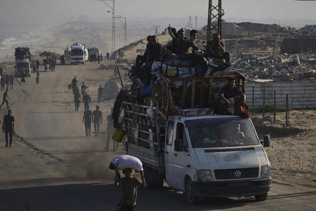 Displaced Palestinians flee Gaza City by foot and vehicles, carrying their belongings along the coastal road toward southern Gaza, Wednesday, Sept. 17, 2025. (AP Photo/Abdel Kareem Hana)
