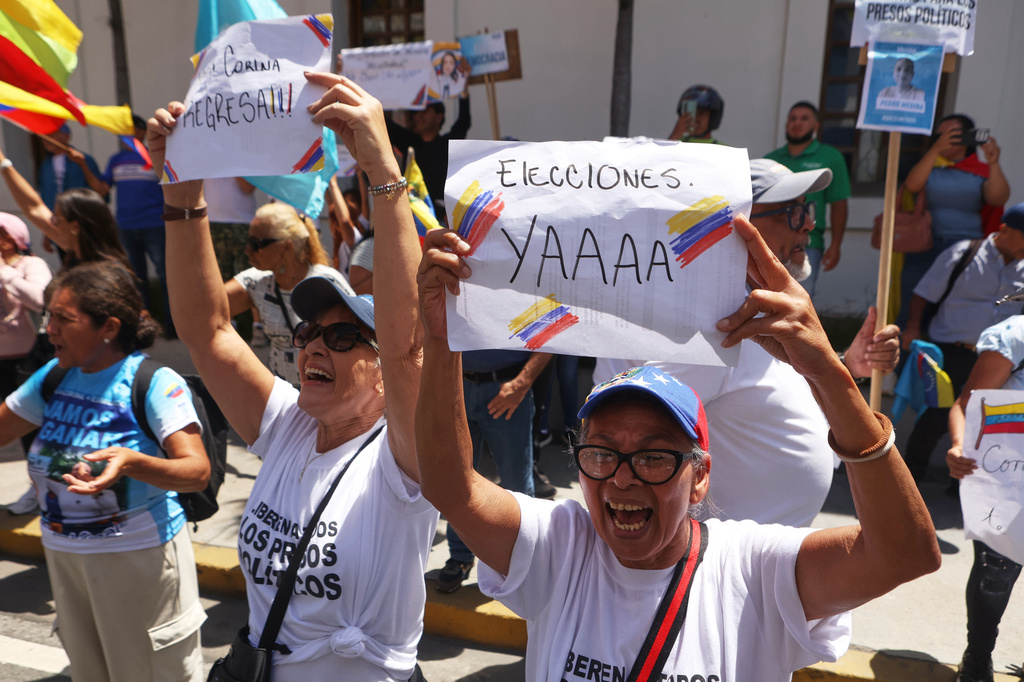 A supporter of opposition leader Maria Corina Machado holds a sign that reads in Spanish: "immediately elections" during a rally calling for her return to the country, in Los Teques, Venezuela, Sunday, Sept. 27, 2026. (AP Photo/Pedro Mattey)