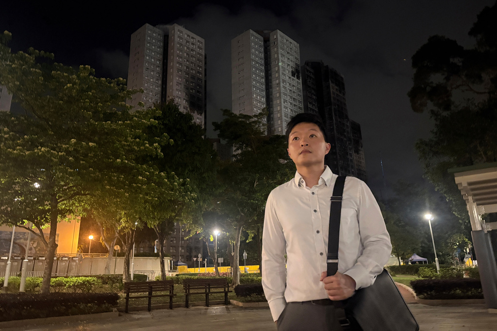 Resident Cyrus Ng poses for photos at a park near Wang Fuk Court, the apartment complex hit by Hong Kong's deadliest fire in decades, Monday, April 13, 2026. (AP Photo/Kanis Leung)