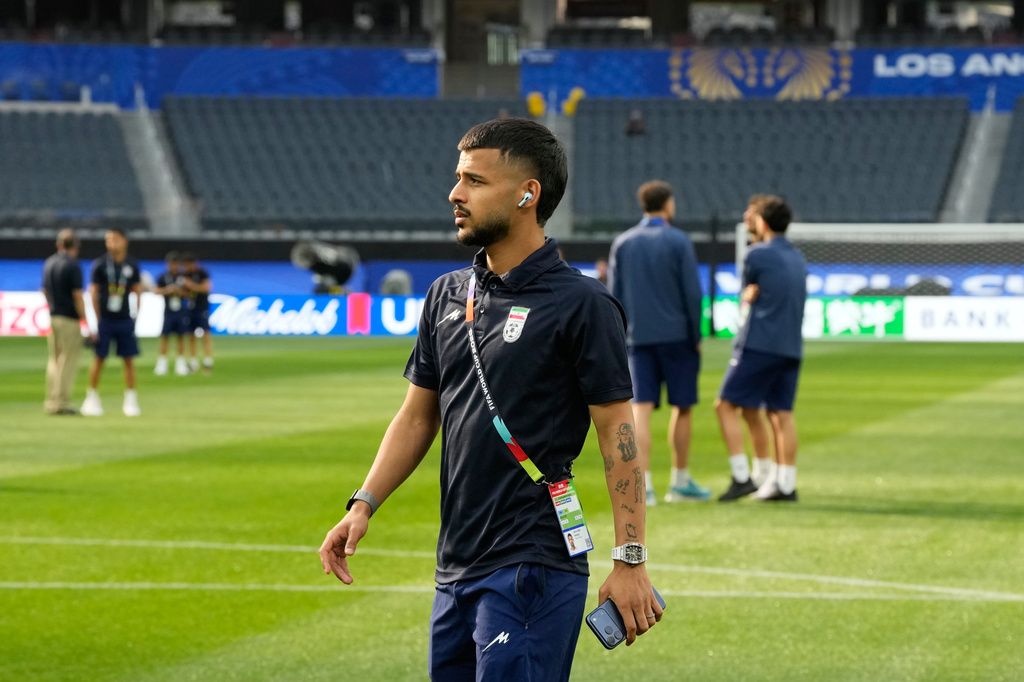 Iran's Mehdi Ghayedi, center, and teammates walk onto the pitch at the stadium one day before their FIFA World Cup match against New Zealand in Inglewood, Calif., near Los Angeles, Sunday, June 14, 2026. (AP Photo/Andre Penner)