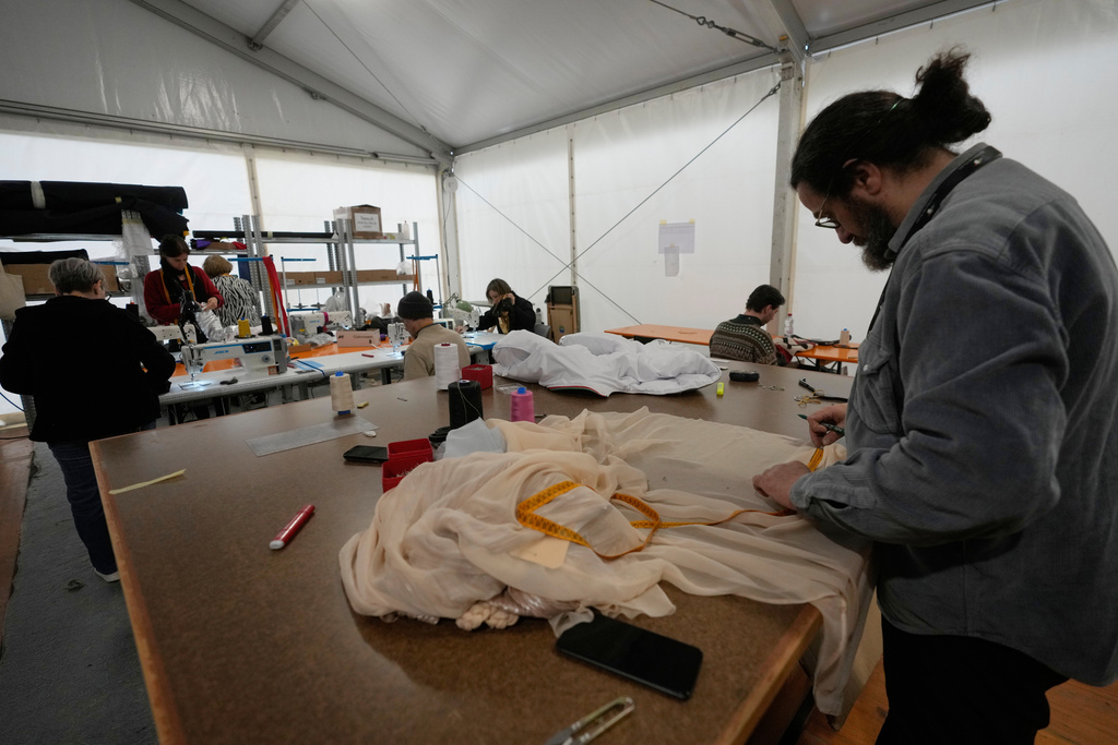 Tailors work on clothes during rehearsals for the opening ceremony of the Milan Cortina 2026 Winter Olympic Games, at a compound in a big tent next to San Siro Stadium, in Milan, Italy, Saturday, Jan. 24, 2026. (AP Photo/Luca Bruno)