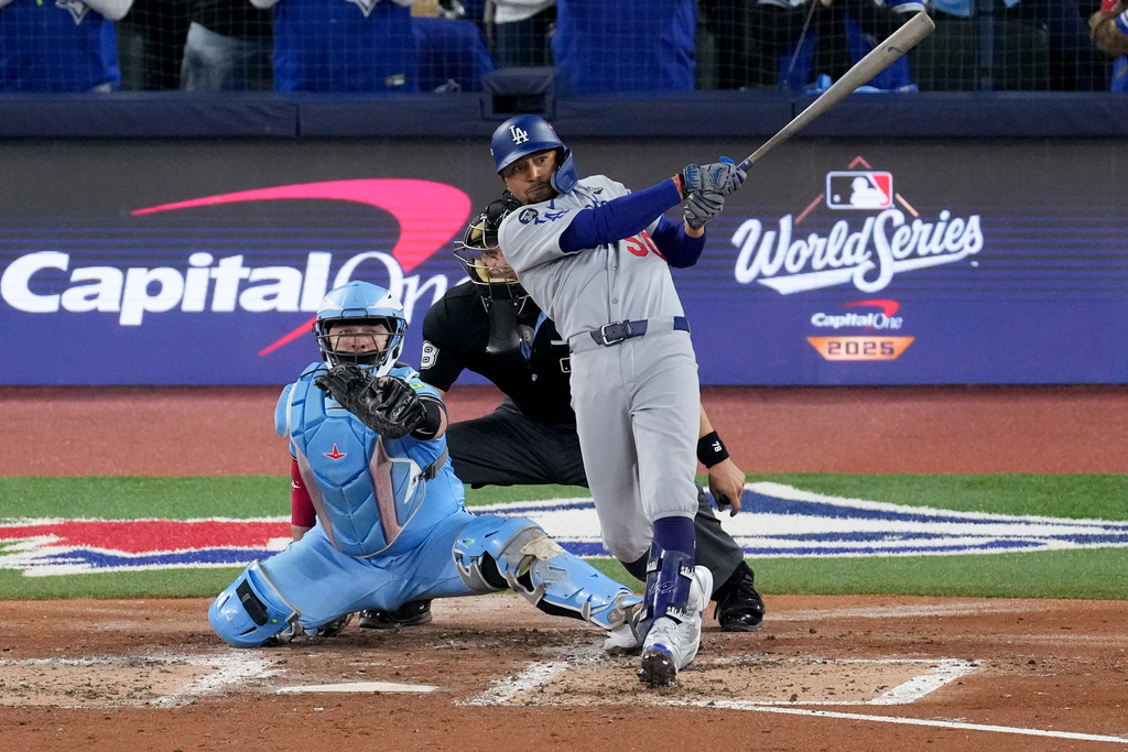Los Angeles Dodgers' Mookie Betts follows through on his two run base hit against the Toronto Blue Jays during the third inning in Game 6 of baseball's World Series, Friday, Oct. 31, 2025, in Toronto. (AP Photo/Ashley Landis)