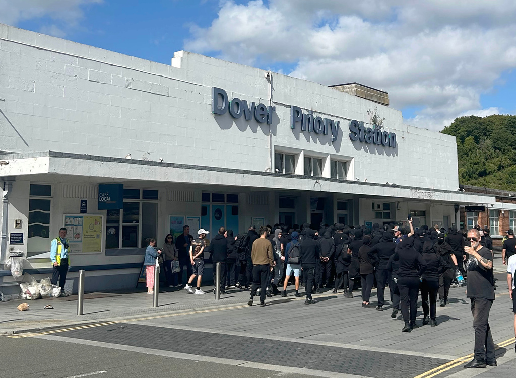 Protesters gather at Dover Priory train station after black-clad and masked demonstrators blocked roads during a protest, in Dover, England, Saturday, Sept. 5, 2026. (Oscar Rihll/PA via AP)