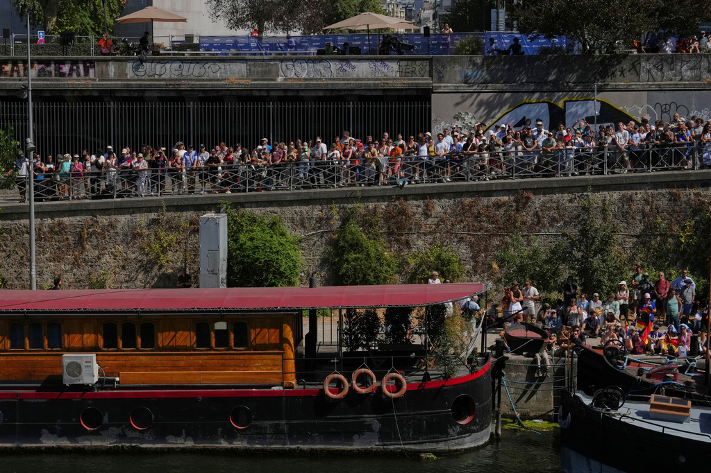 Spectators line the banks of the Seine river to watch the 20m Platform high diving at the European Aquatics Championships in Paris, Friday, Aug. 7, 2026. (AP Photo/Aurelien Morissard)