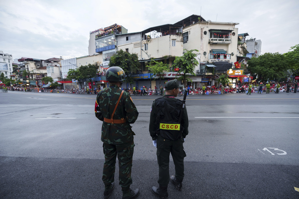 Vietnamese Army and security personal stand guard before a military parade rehearsal for the Vietnam's 80th National Day celebration in old town of Hanoi, Vietnam, Saturday, Aug. 30, 2025. (AP Photo/Vincent Thian)