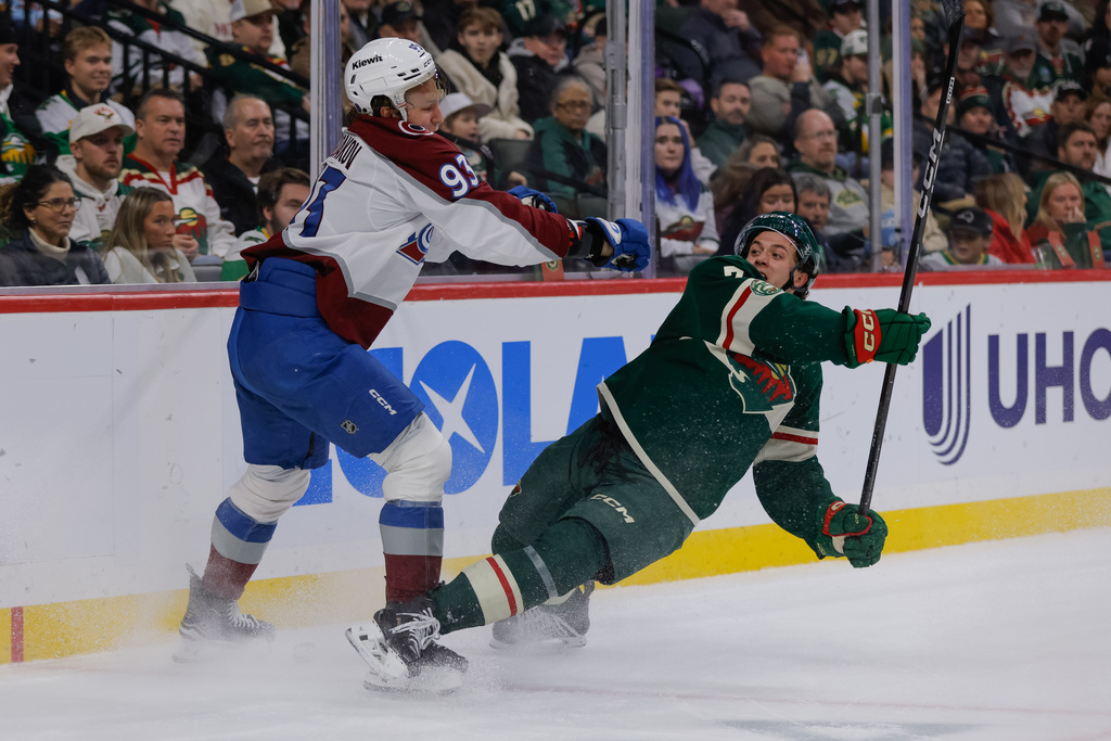 Colorado Avalanche center Zakhar Bardakov checks Minnesota Wild defenseman Brock Faber during the second period of an NHL hockey game, Friday, Nov. 28, 2025, in St. Paul, Minn. (AP Photo/Bailey Hillesheim)