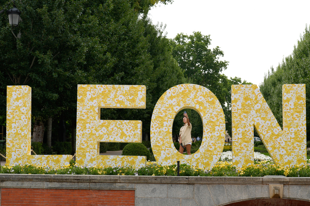 Visitors pose for photos next to a sign bearing the name of Pope Leo XIV in Madrid, Spain, Saturday, June 6, 2026. (AP Photo/Bernat Armangue)