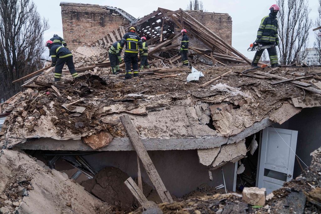 Rescue workers clear the rubble at the roof of apartment building damaged after a Russian strike on Kyiv, Ukraine, on Saturday, Dec. 27, 2025. (AP Photo/Evgeniy Maloletka)