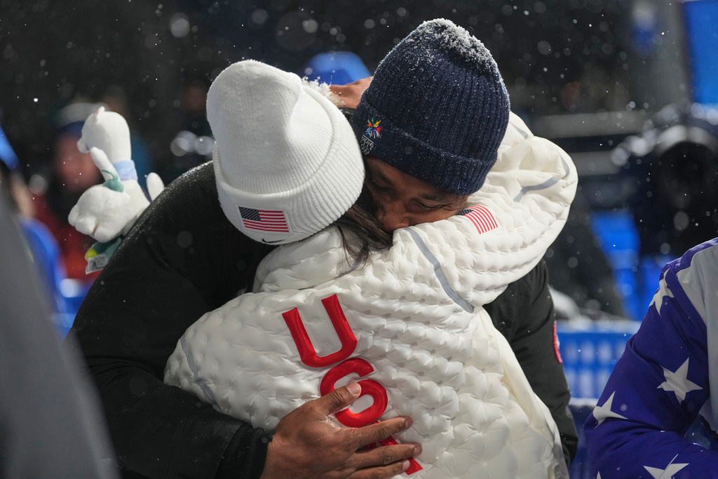 United States' Chloe Kim and Cleveland Browns' Myles Garrett hug after Kim won the silver medal in the women's snowboarding halfpipe finals at the 2026 Winter Olympics, in Livigno, Italy, Thursday, Feb. 12, 2026. (AP Photo/Lindsey Wasson)