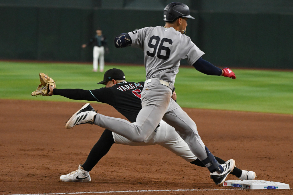 Arizona Diamondbacks' Ildemaro Vargas, left, catches out New York Yankees' George Lombard Jr. (96) during the eighth inning of a baseball game, Sunday, Sept. 20, 2026, in Phoenix. (AP Photo/Caitlin O'Hara)wld