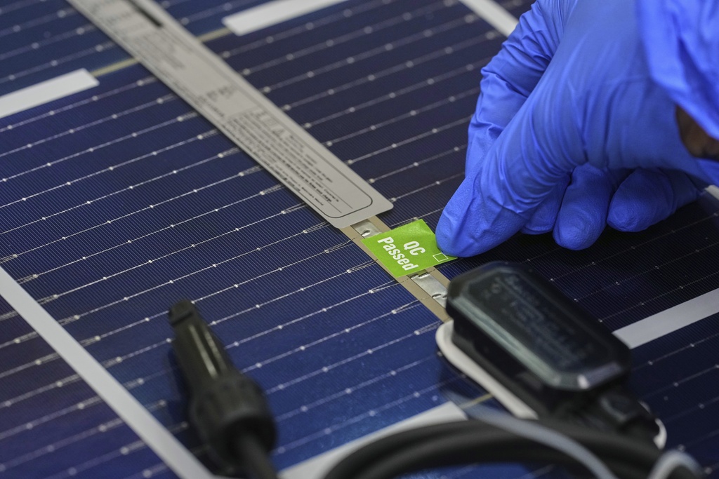 A worker puts a passed sticker of quality after an inspection of a solar panel at a ReNew manufacturing facility on the outskirts of Jaipur, India, Thursday, Aug. 21, 2025. (AP Photo/Manish Swarup)