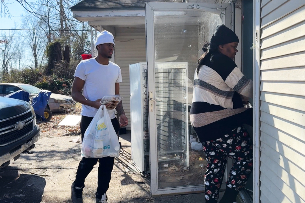 Chiquitta Fields and her son bring their belongings inside their home on Monday, Feb. 2, 2026, in Belzoni, Miss.. (AP Photo/Sophie Bates)