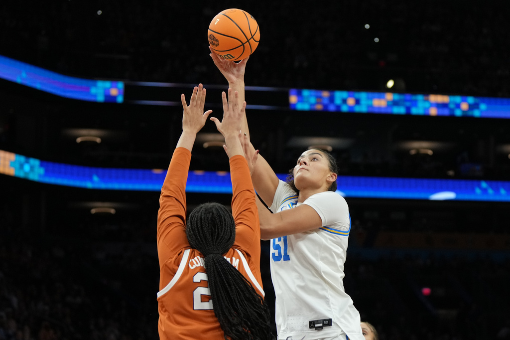 UCLA center Lauren Betts (51) shoots over Texas forward Breya Cunningham (25) during the second half of a women's NCAA college basketball tournament semifinal game at the Final Four, Friday, April 3, 2026, in Phoenix. (AP Photo/Rick Scuteri)