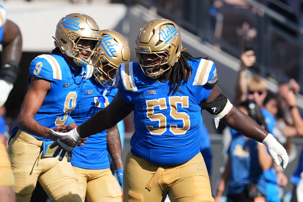UCLA quarterback Nico Iamaleava (9) celebrates his rushing touchdown with offensive lineman Eugene Brooks (55) during the second half of an NCAA college football game against Penn State Saturday, Oct. 4, 2025, in Pasadena, Calif. (AP Photo/Marcio Jose Sanchez)