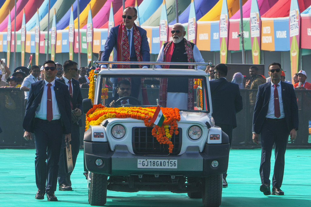 German Chancellor Friedrich Merz and Indian Prime Minister Narendra Modi ride together in a vehicle during the inauguration of International kite festival in Ahmedabad, India, Monday, Jan. 12, 2026. (AP Photo/Ajit Solanki)