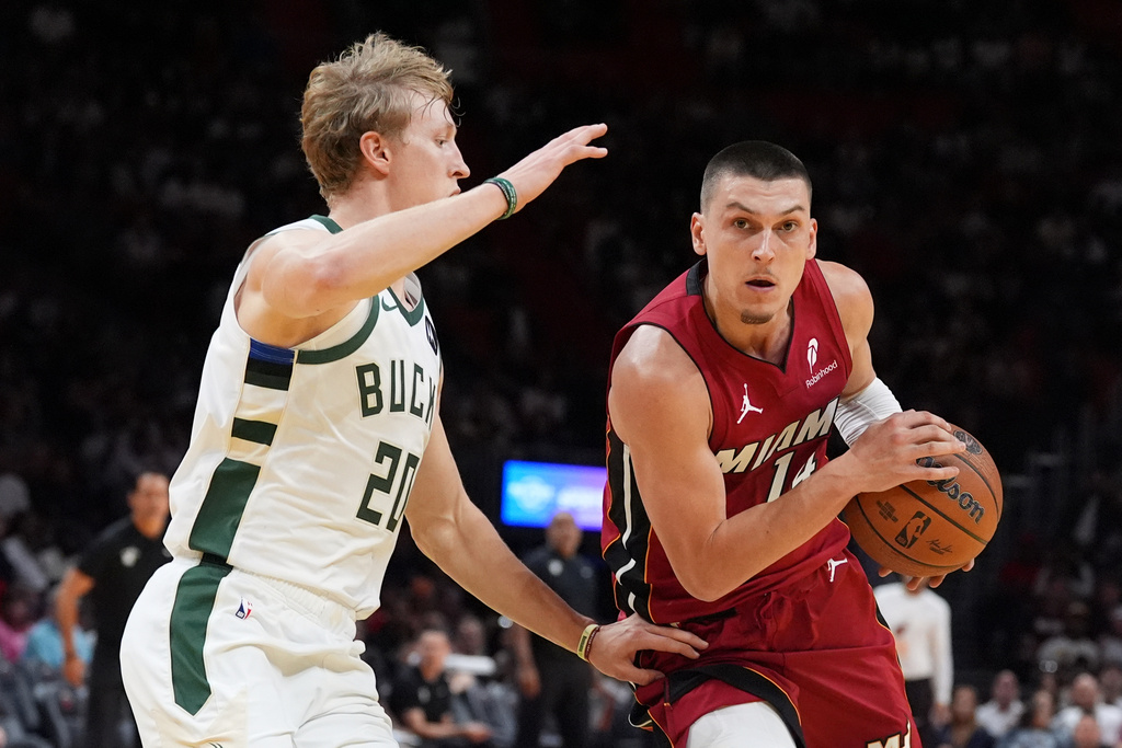 Miami Heat guard Tyler Herro (14) drives past Milwaukee Bucks guard AJ Green (20) during the first half of an Emirates NBA Cup basketball game, Wednesday, Nov. 26, 2025, in Miami. (AP Photo/Rebecca Blackwell)