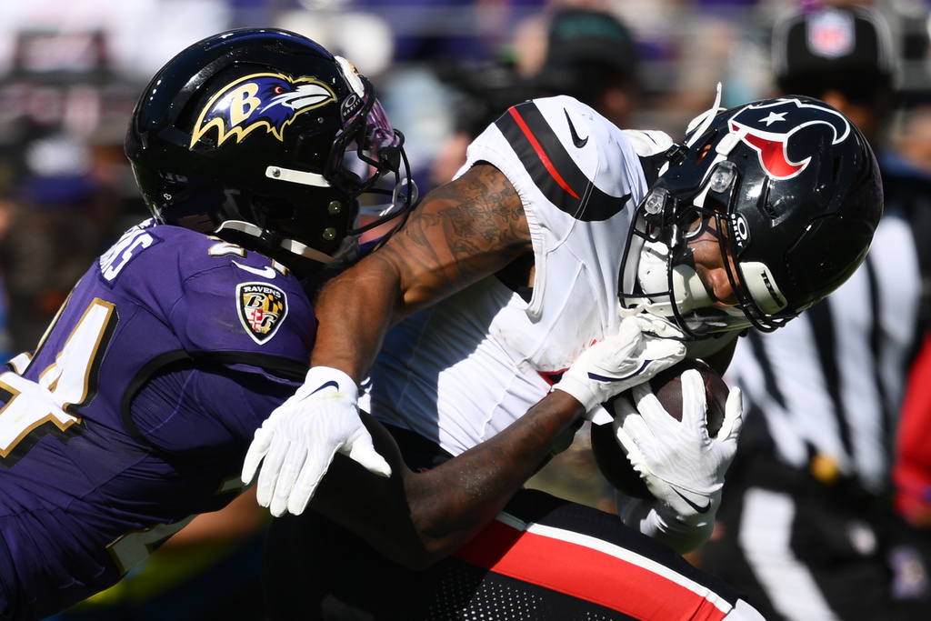 Baltimore Ravens safety Malaki Starks (24) grabs the facemask of Houston Texans wide receiver Christian Kirk (13) during the second half of an NFL football game, Sunday, Oct. 5, 2025, in Baltimore. (AP Photo/Nick Wass)