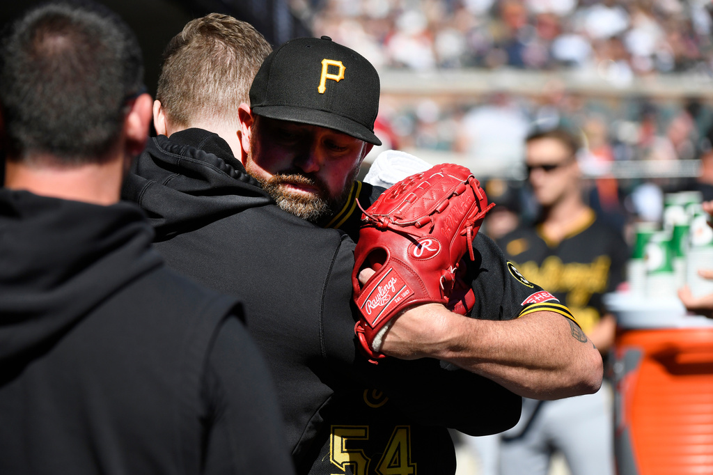 Pittsburgh Pirates starting pitcher Kirby Yates, right foreground, is hugged by a teammate after being taken out of the game during the second inning of a baseball game against the Detroit Tigers, Saturday, Sept. 26, 2026, in Detroit. (AP Photo/Jose Juarez)