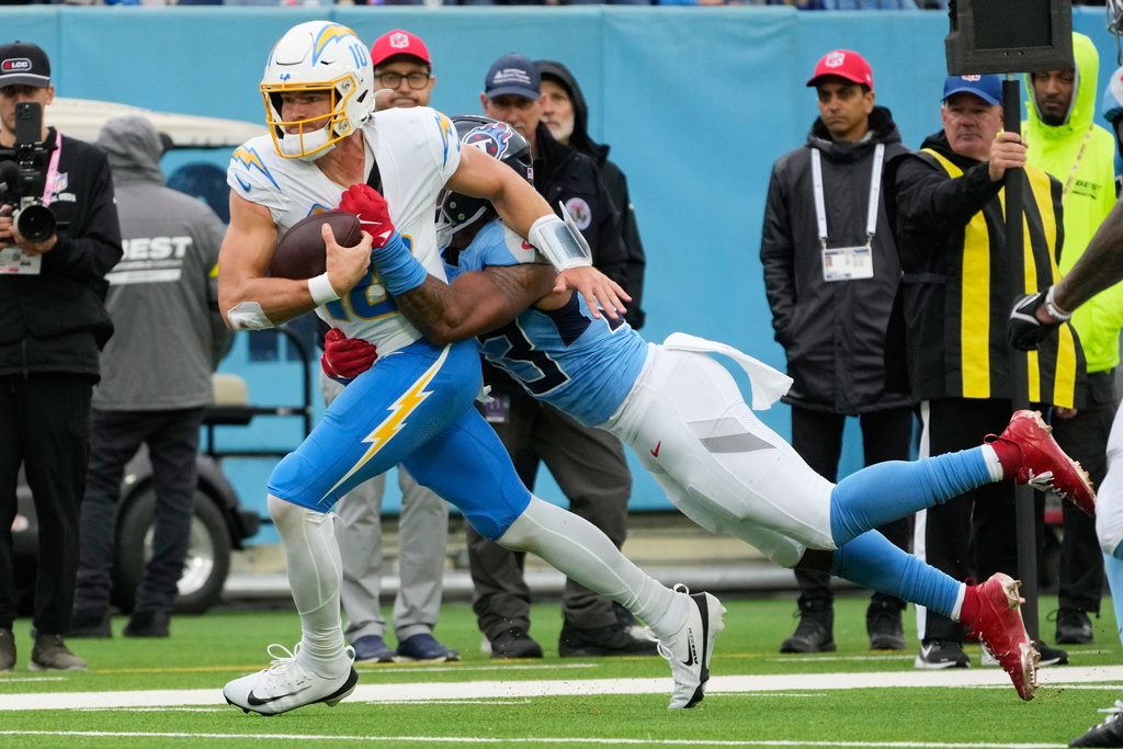 Los Angeles Chargers quarterback Justin Herbert, left, is tackled by Tennessee Titans linebacker Cedric Gray during the second half of an NFL football game Sunday, Nov. 2, 2025, in Nashville, Tenn. (AP Photo/George Walker IV)