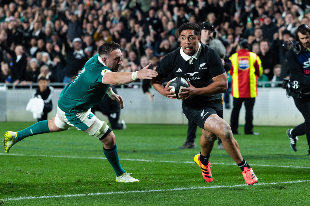 New Zealand's Anton Lienert-Brown, right, breaks a tackle from Ireland to score a try during their Nations Championship rugby international test match in Auckland, New Zealand, Saturday, July 18, 2026. (Brett Phibbs/Photosport via AP)
