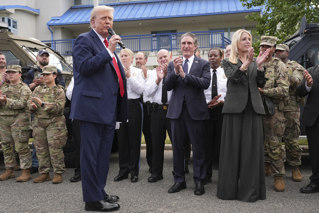President Donald Trump speaks with members of law enforcement and National Guard soldiers, Thursday, Aug. 21, 2025, in Washington, as Interior Secretary Doug Burgum and Attorney General Pam Bondi listen. (AP Photo/Jacquelyn Martin)