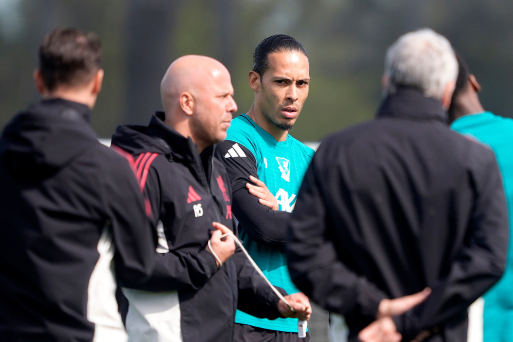 Liverpool's Virgil van Dijk, center, and manager Arne Slot, second left, attend a training session in Liverpool, England, Tuesday April 7, 2026. (Peter Byrne/PA via AP)