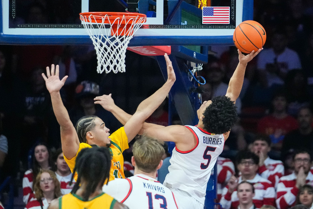 Arizona guard Brayden Burries (5) shoots against Norfolk State forward Devon Ellis, left, during of an NCAA college basketball game Saturday, Nov. 29, 2025, in Tucson, Ariz. (AP Photo/Darryl Webb)