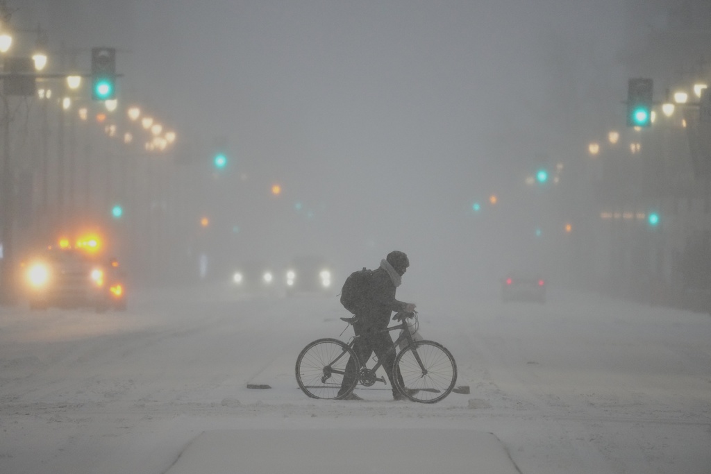 A person pushed a bicycle during a winter storm in Philadelphia, Sunday, Jan. 25, 2026. (AP Photo/Matt Rourke)