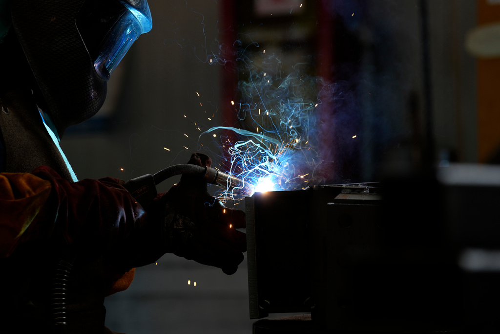 FILE -A man works at MAP, a factory operating in design, manufacture and installation of steel structures for civil and industrial use, in Corsico, near Milan, Italy, Thursday, May 12, 2022. (AP Photo/Antonio Calanni, File)
