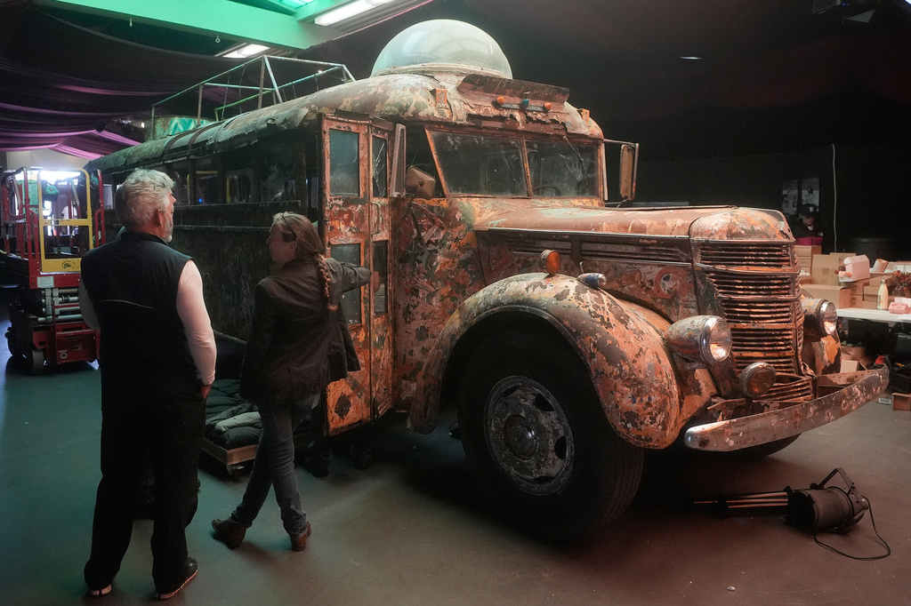 Eric Pirone, left, looks toward Ken Kesey's psychedelic bus "Furthur" where it will be displayed at the Forever Grateful exhibit presented by the Haight Street Art Center at the County Fair Building in Golden Gate Park, Tuesday, Sept. 1, 2026, in San Francisco. (AP Photo/Jeff Chiu)