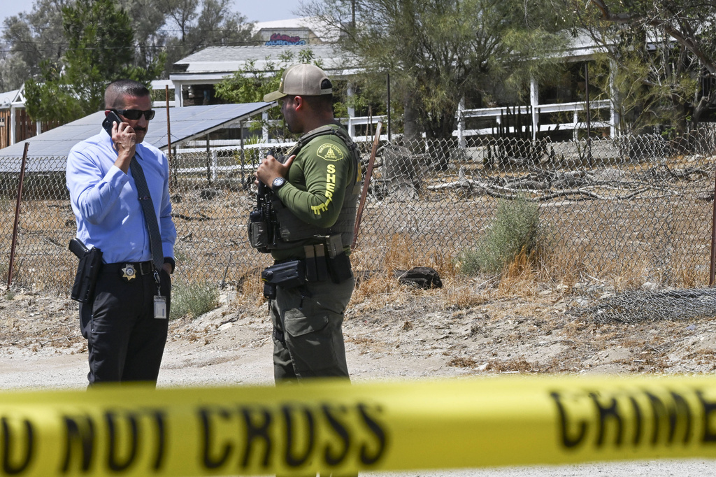 San Bernardino County Detective Eduardo Badillo, lefr, speaks on the phone alongside a Riverside County Sheriff's officer outside the home of Rebecca and Jake Haro, parents of missing 7-month-old Emmanuel Haro, on Friday, Aug. 22, 2025, in Cabazon, Calif. (Anjali Sharif-Paul/The Orange County Register via AP)