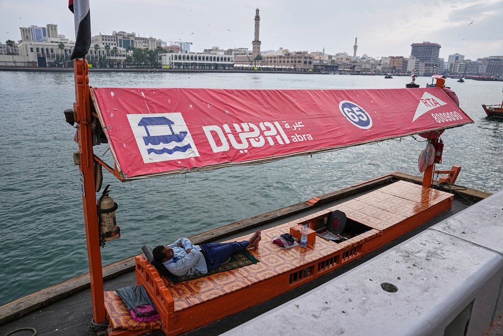 An abra driver sleeps in his boat along Dubai Creek in Dubai, United Arab Emirates, Tuesday, March 10, 2026. (AP Photo/Fatima Shbair)