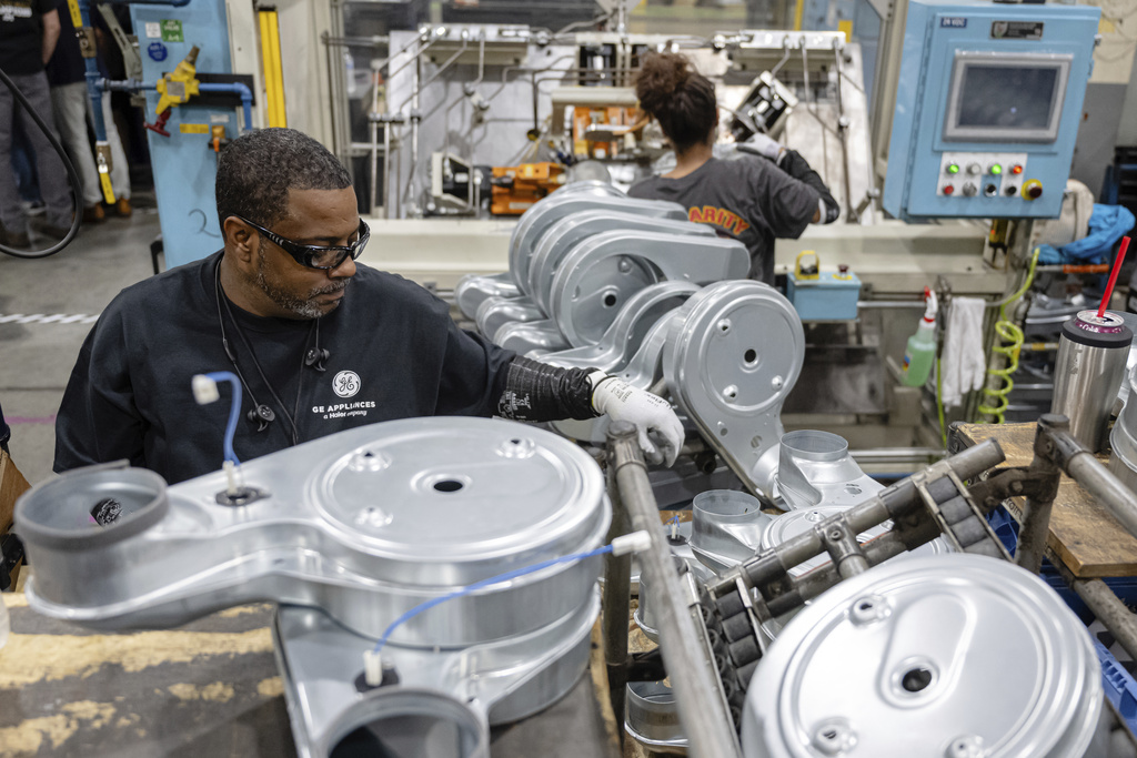 Employees piece together components on an assembly line at GE Appliances global headquarters, Wednesday, Aug 13, 2025, in Louisville, Ky. (AP Photo/Jon Cherry)