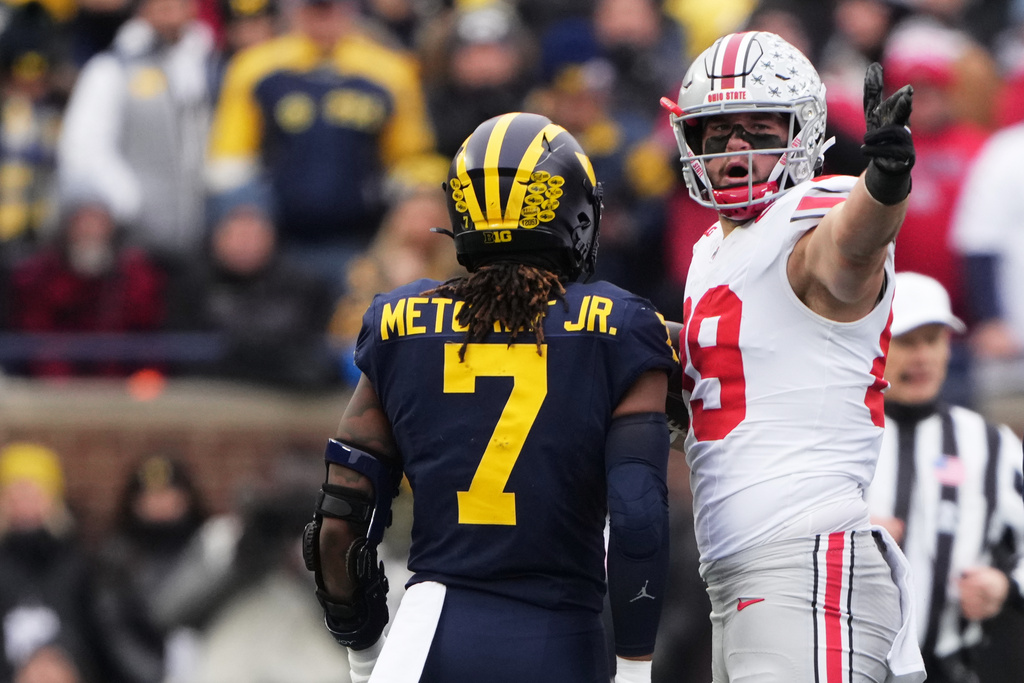 Ohio State tight end Will Kacmarek, right, celebrates near Michigan defensive back TJ Metcalf after a first down during the first half of an NCAA college football game, Saturday, Nov. 29, 2025, in Ann Arbor, Mich. (AP Photo/Ryan Sun)