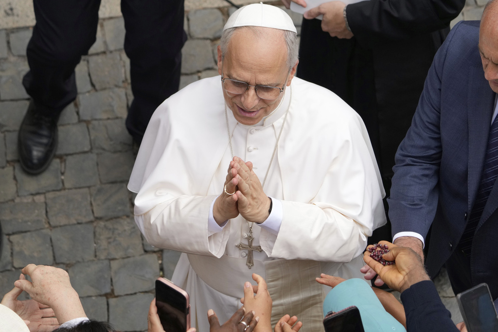 Pope Leo XIV greets faithful at the end of the Angelus prayer in Castel Gandolfo, Italy, Friday, Aug.15, 2025. (AP Photo/Gregorio Borgia)