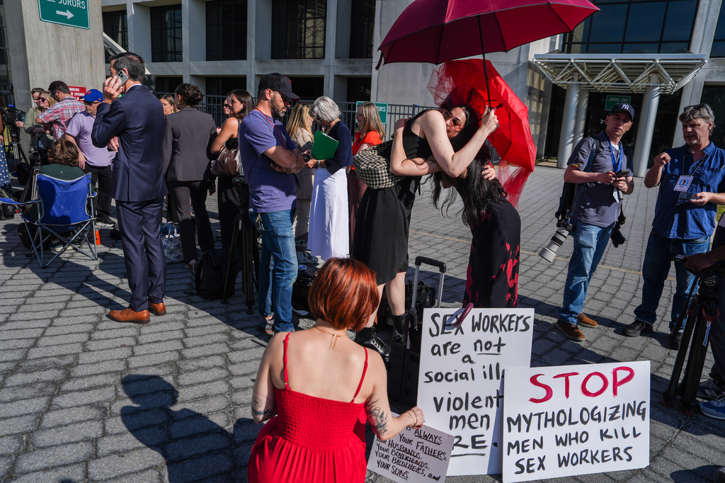 Members of a sex-workers rights group, hug each other while waiting in line to enter the Arthur M. Cromarty Criminal Court Complex ahead of a court sentencing for convicted murderer, Rex Heuermann, Wednesday, June 17, 2026, in Suffolk County, New York. (AP Photo/Ryan Murphy)