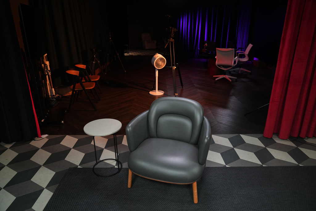 An empty chair takes center stage at a TV studio set where imprisoned Turkish journalist Fatih Altayli continues to deliver news on his YouTube show through letters read by his assistant, in Istanbul, Wednesday, Oct. 1, 2025. (AP Photo/Francisco Seco)