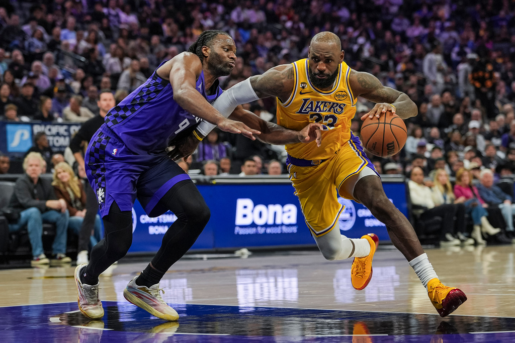 Los Angeles Lakers forward LeBron James, right, dribbles against Sacramento Kings forward Precious Achiuwa (9) during the first half of an NBA basketball game, Monday, Jan. 12, 2026, in Sacramento, Calif. (AP Photo/Justine Willard)