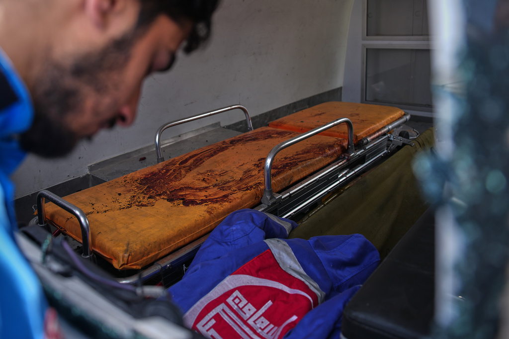 A member of the Nabatiyeh Emergency Services looks inside a damaged ambulance stained with the blood of his colleague, who was killed during a rescue mission in an Israeli airstrike on Wednesday, in Nabatiyeh, southern Lebanon, Friday, April 17, 2026. (AP Photo/Hassan Ammar)