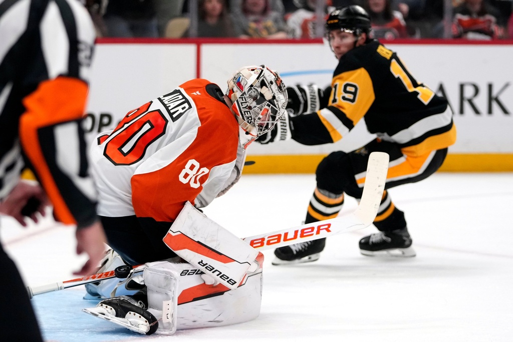 Philadelphia Flyers goaltender Dan Vladar (80) stops a shot by Pittsburgh Penguins' Connor Dewar (19) during the second period of an NHL hockey game in Pittsburgh, Saturday, March 7, 2026. (AP Photo/Gene J. Puskar)